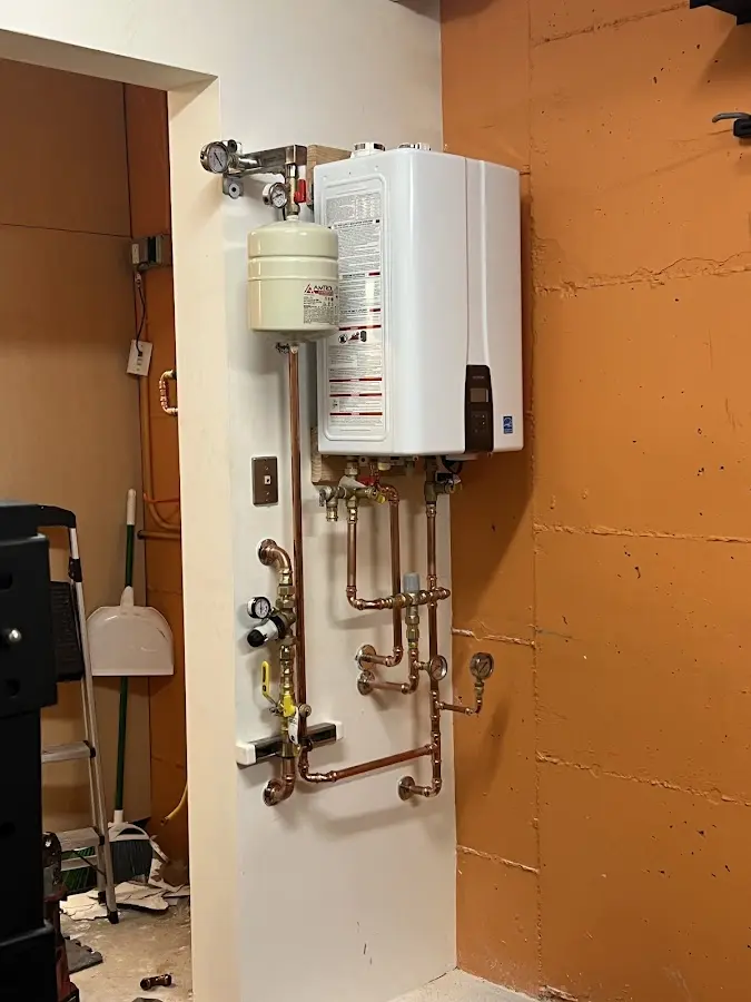 Plumbing technician inspecting water heater connections in Mountainside
